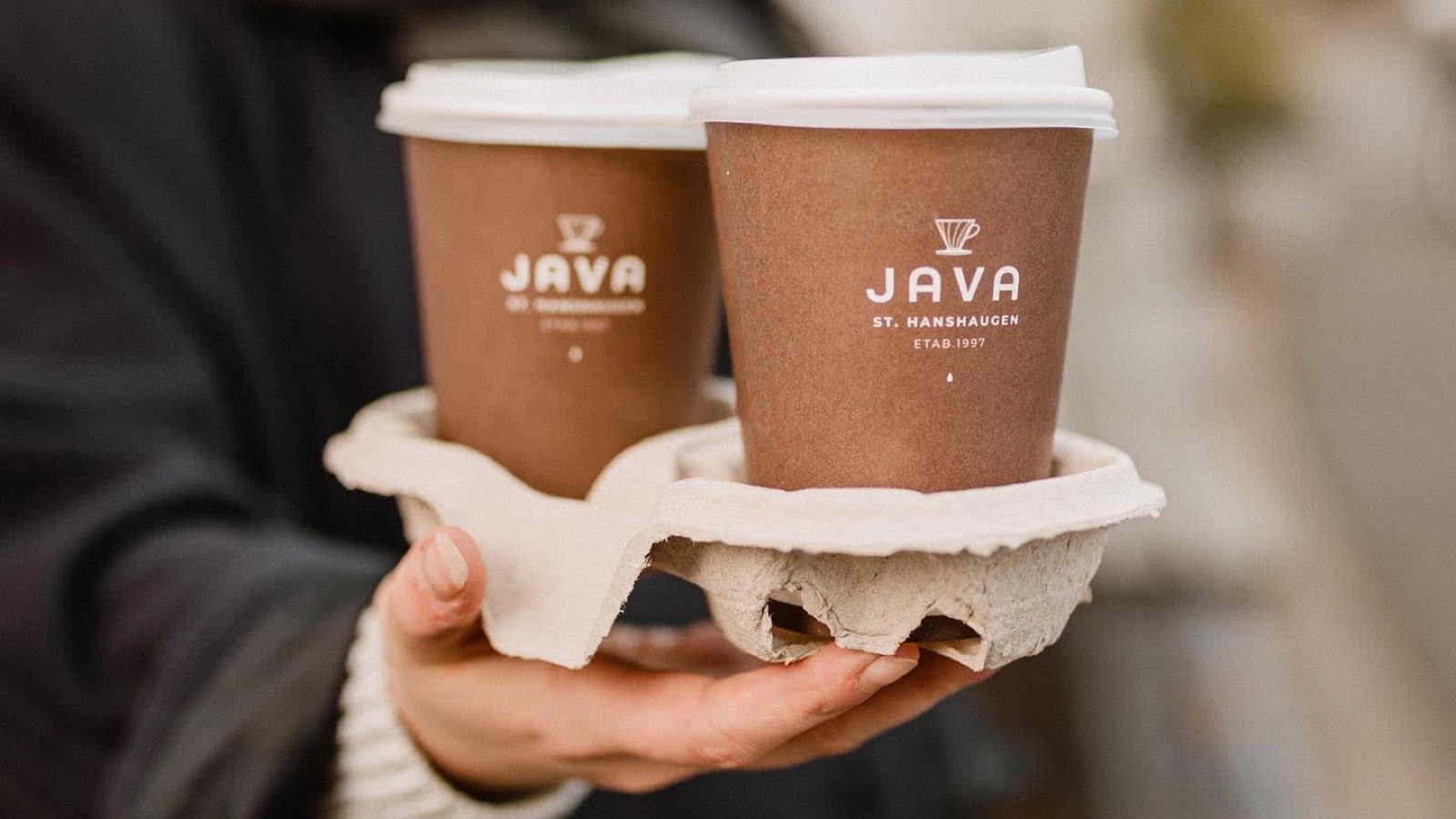 Java St. Hanshaugen coffee cup branding held in hand